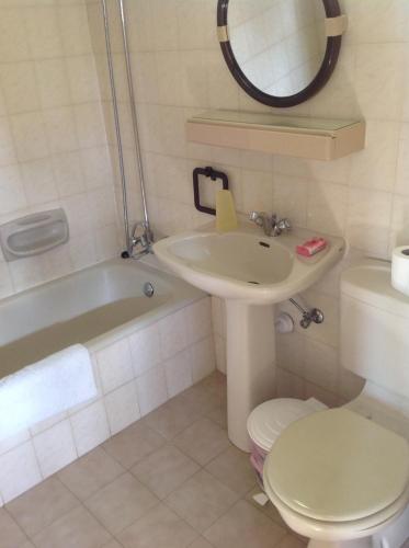 a bathroom with a sink and a toilet and a mirror at Sea N Lake View Hotel Apartments in Larnaka