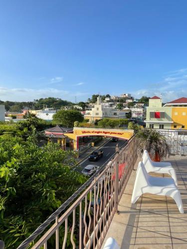 a balcony with a white chair and a view of a city at Rincon Plaza Hotel in Rincon