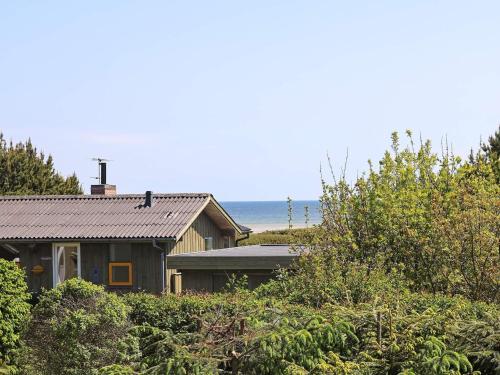 een huis met de oceaan op de achtergrond bij 4 person holiday home in Hadsund in Haslevgårde