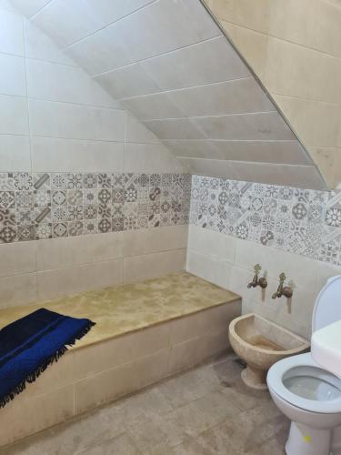 a bathroom with a bath tub and a toilet at La petite villa avec piscine pieds dans l'eau in Sidi Rahal