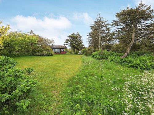 a field of grass with a house in the background at 6 person holiday home in Vinderup in Vinderup