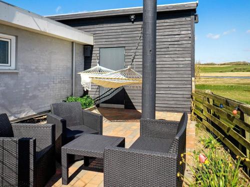 eine Terrasse mit Stühlen und einer Hängematte auf einem Haus in der Unterkunft 8 person holiday home in Hurup Thy in Helligsø