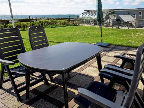 einen Tisch und Stühle auf einer Terrasse mit Meerblick in der Unterkunft 8 person holiday home in Hurup Thy in Helligsø