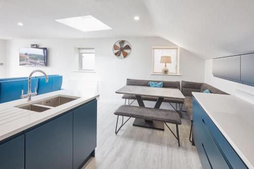 una cocina con armarios azules y blancos y una mesa. en Host & Stay - The Townhouse en Whitby