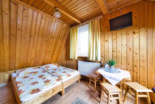 a bedroom with a bed and a table with chairs at Kwatery Maciata in Biały Dunajec