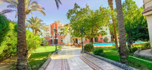 un complejo con piscina y palmeras en Green Garden Resort, en Hurghada
