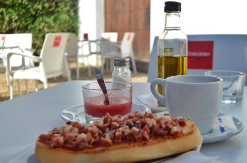 Una pizza en una mesa con una taza y una bebida. en Hotel Plateros, en Córdoba