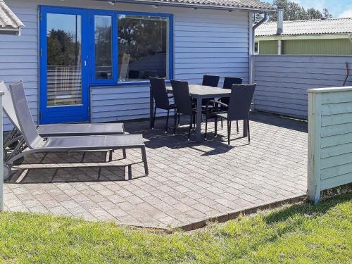 un patio con mesa y sillas frente a una casa en 4 person holiday home in S by, en Nordost