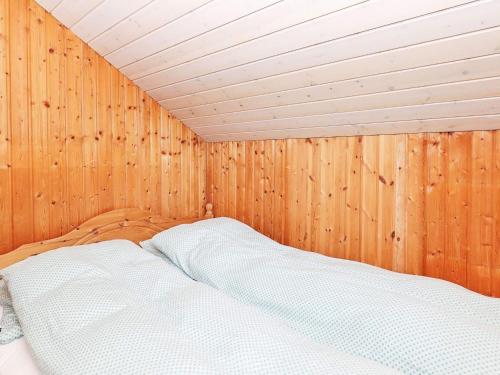 una camera da letto con pareti in legno e un letto interno di 8 person holiday home in Bl vand a Blåvand
