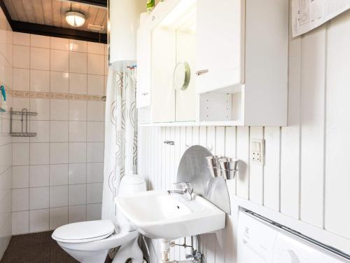 een witte badkamer met een toilet en een wastafel bij Holiday home Fanø LXXIX in Fanø