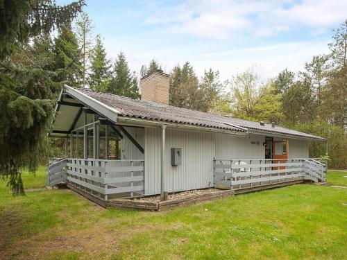 a small white house with a porch in a yard at 6 person holiday home in Ans By in Roe