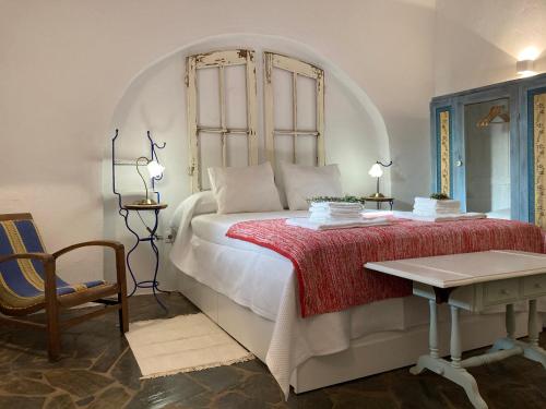 a bedroom with a bed with a table and a chair at Monte do Pombal in Sousel