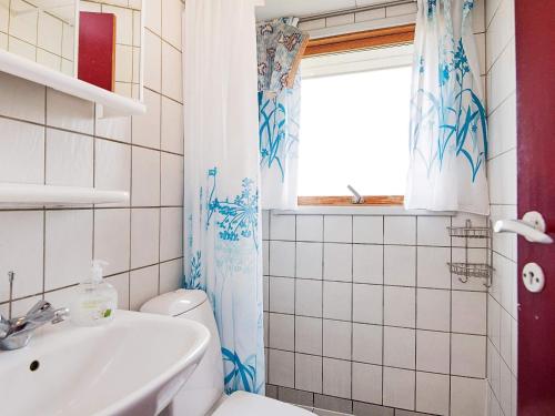 ein Bad mit einem WC, einem Waschbecken und einem Fenster in der Unterkunft 5 person holiday home in Fan in Fanø