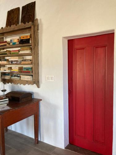 a red door in a room with a desk and books at Monte do Pombal in Sousel