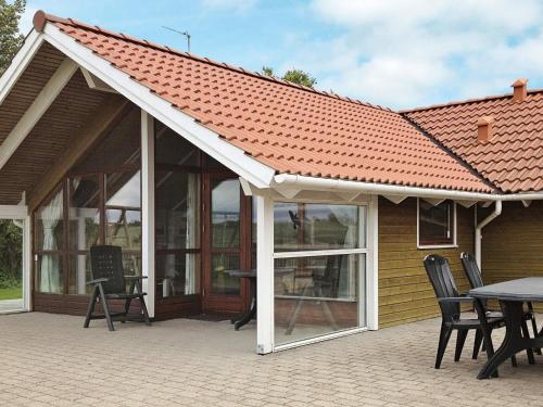 einen Pavillon mit einem Tisch und Stühlen auf einer Terrasse in der Unterkunft 7 person holiday home in Broager in Broager