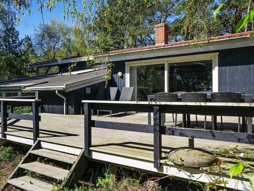 a wooden deck with chairs and a house at 14 person holiday home in Nex in Snogebæk