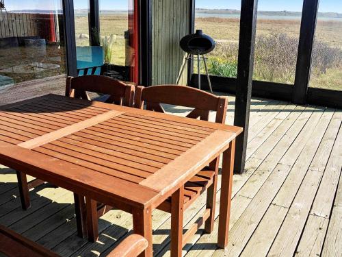 a wooden table and chairs on a wooden deck at 5 person holiday home in Harbo re in Harboør