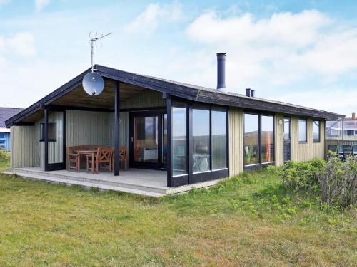a small house with a deck and a table at 5 person holiday home in Harbo re in Harboør
