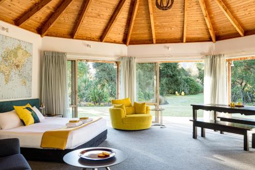 ein Schlafzimmer mit einem Bett, einem Sofa und einem Tisch in der Unterkunft Abel Tasman Lodge in Marahau