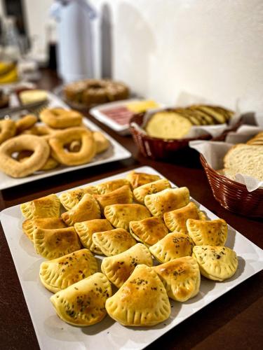 a table topped with plates of pastries and pretzels at Pousada Flor do Campestre in Urubici