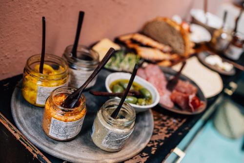 a table with a plate of food with jars of food at Boulenc Bed and Bread in Oaxaca City