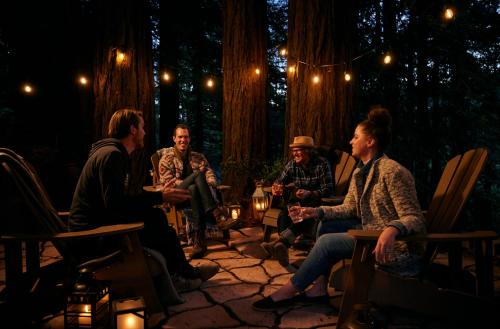 a group of people sitting around a patio in a forest at Highlands Resort in Guerneville