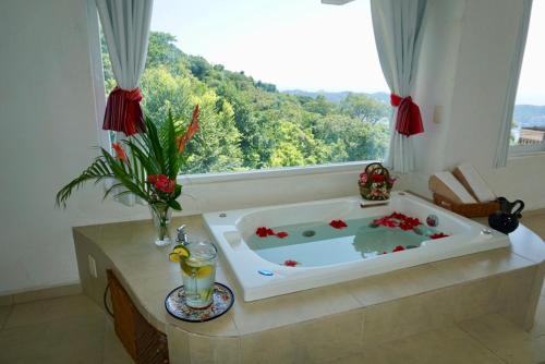 een bad in een kamer met een raam bij Mexican Condo by the sea in Acapulco