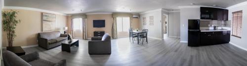 ein großes Wohnzimmer mit einem Sofa und einem Tisch in der Unterkunft Alexis Park All Suite Resort in Las Vegas