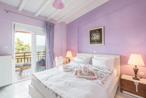 ネオス・マルマラスにある2 bedrooms appartement at Neos Marmaras 500 m away from the beach with sea view and enclosed gardenの紫の壁のベッドルーム、ベッド、バルコニーが備わります。