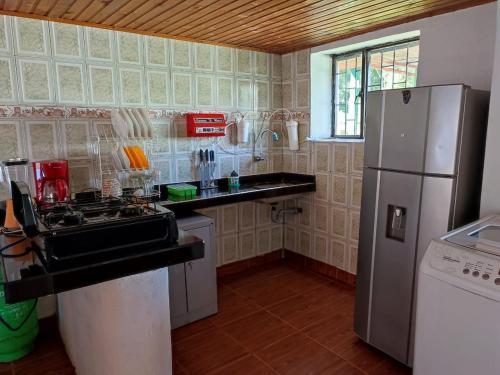 Cabañas La Campiña Ubalá في Ubalá: مطبخ مع موقد وثلاجة