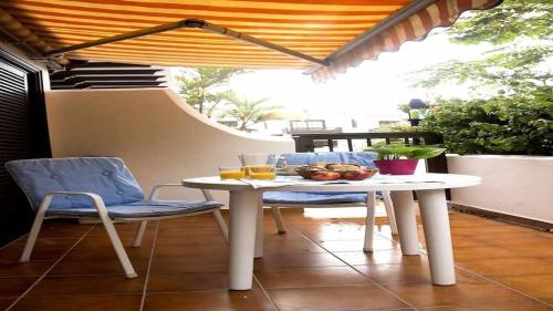 uma mesa branca e cadeiras num pátio em Apartamento con jardín y piscina B em Puerto de la Cruz