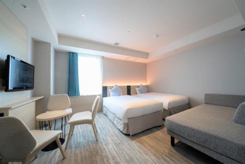 Кровать или кровати в номере Hotel Oriental Express Fukuoka Tenjin