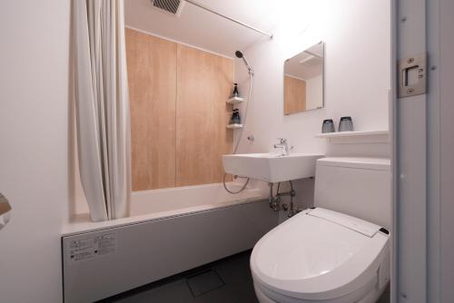 a white bathroom with a toilet and a sink at Hotel Oriental Express Fukuoka Tenjin in Fukuoka