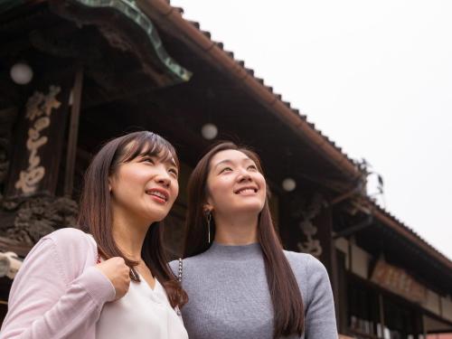 two women standing next to each other in front of a building at Kotohira Park Hotel in Kotohira