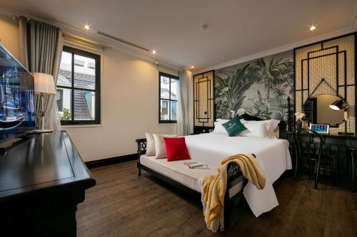 een slaapkamer met een groot wit bed en een bank bij Green Suites Hotel in Ha Long