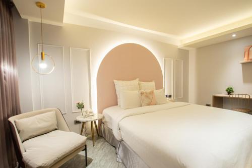 sypialnia z dużym łóżkiem i krzesłem w obiekcie 里萊行旅 - 桃園館 w mieście Taoyuan
