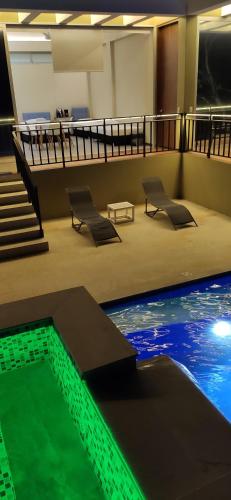 a building with a swimming pool with chairs and stairs at Mountain View Anapoima in Anapoima