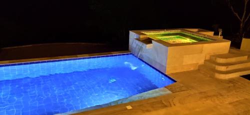 a swimming pool at night with a platform and stairs at Mountain View Anapoima in Anapoima