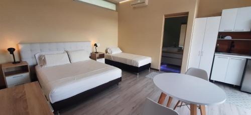 a bedroom with two beds and a table and a kitchen at Mountain View Anapoima in Anapoima