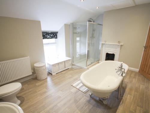 a bathroom with a tub and a toilet and a sink at Pen Y Bryn Cottage in Llanddoget