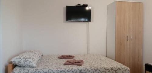 a bedroom with a bed with slippers on it at Apartmani Ilić in Golubac