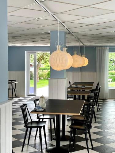 a dining room with tables and chairs and lights at Egn Boutique Hotel in Stege