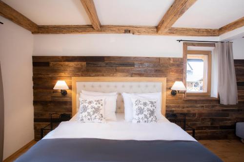 a bedroom with a bed with a wooden wall at House Troha - Rooms & Apartments in Bled