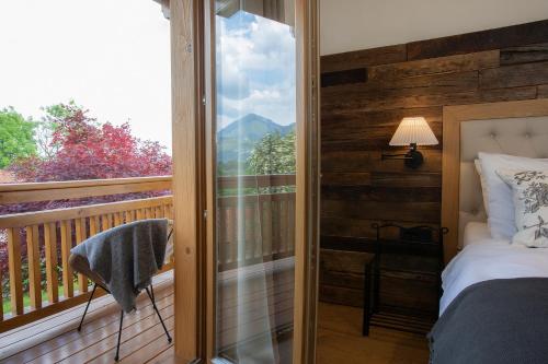 a bedroom with a balcony with a bed and a window at House Troha - Rooms & Apartments in Bled