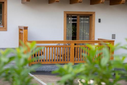 a house with a wooden porch with a door at House Troha - Rooms & Apartments in Bled