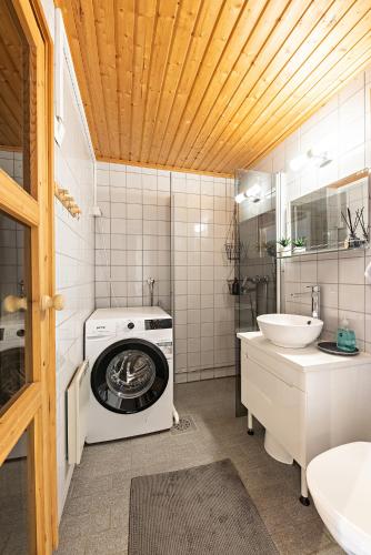 a bathroom with a washing machine and a sink at UnelmaHelmi in Ruka