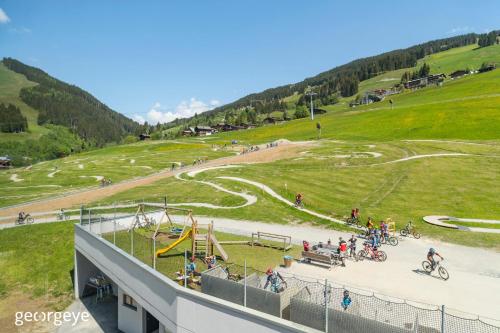 a group of people in a park with a playground at Appartements Bernhofer in Saalbach Hinterglemm