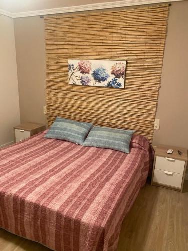 a bedroom with a bed with two pillows at BUNGALOW LA ISLA in Jávea