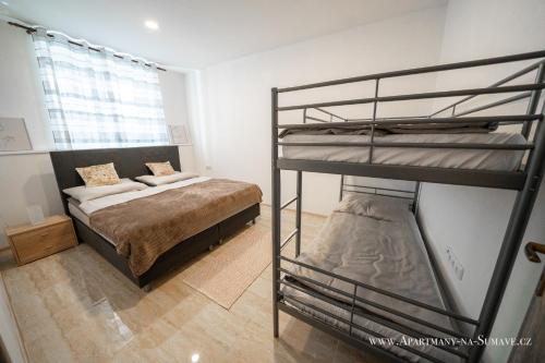 a bedroom with two bunk beds and a bed at Apartmány na Šumavě in Stachy