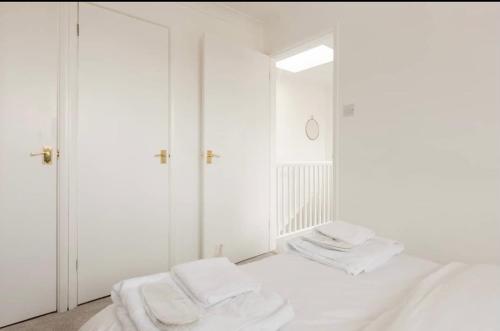 a white room with two beds and a mirror at Rose Mews Central Broadstairs in Kent